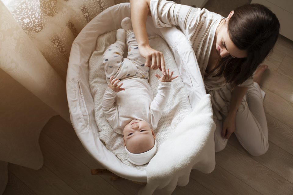 Little Baby Lying In Crib And Young Mother Sits About It Happy Family 