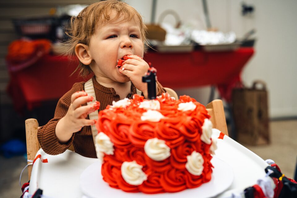 Baby stopft sich Kuchen in den Mund