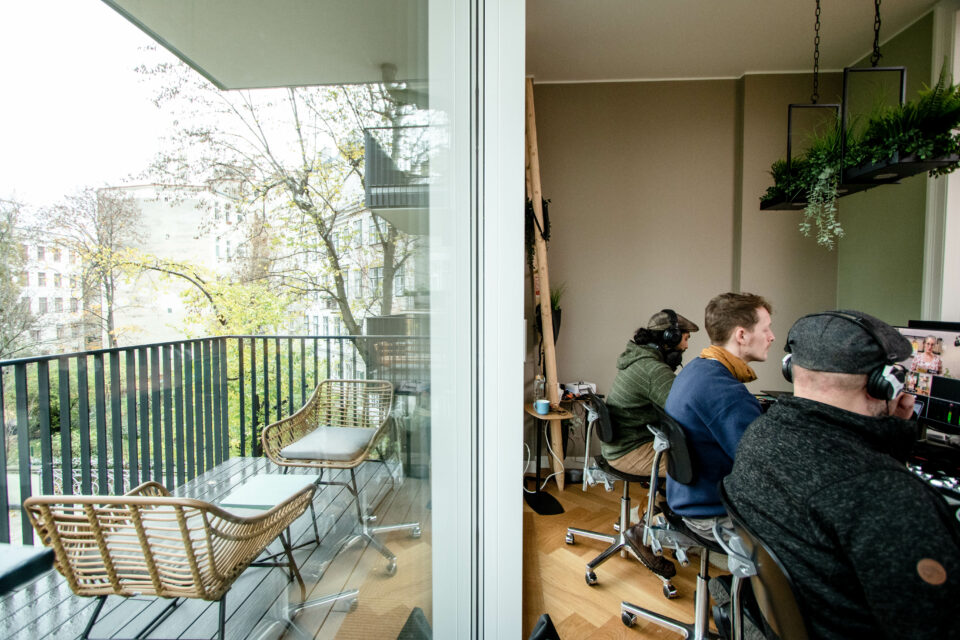 Filmcrew sitzt vor dem Balkon