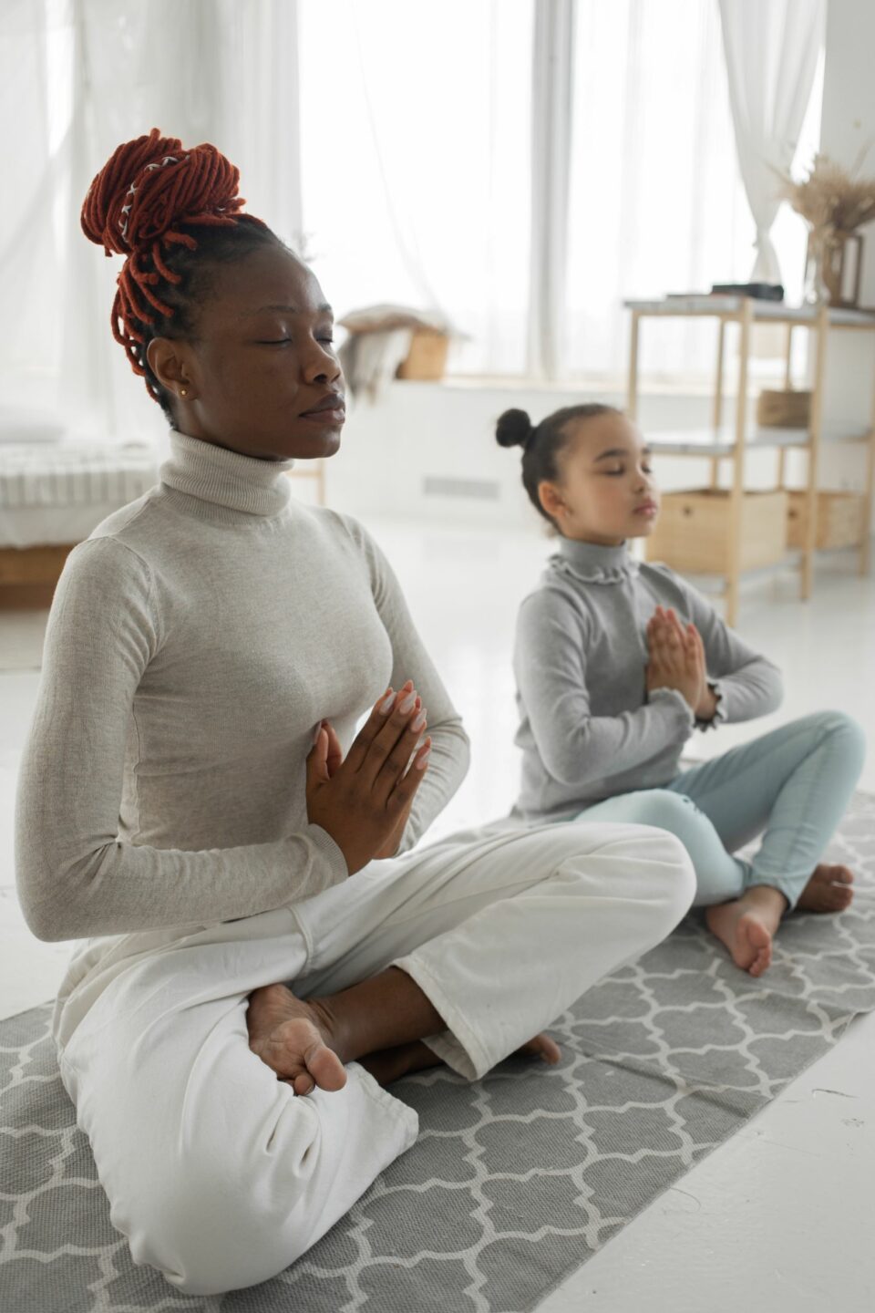 Frau und Kind meditieren gemeinsam