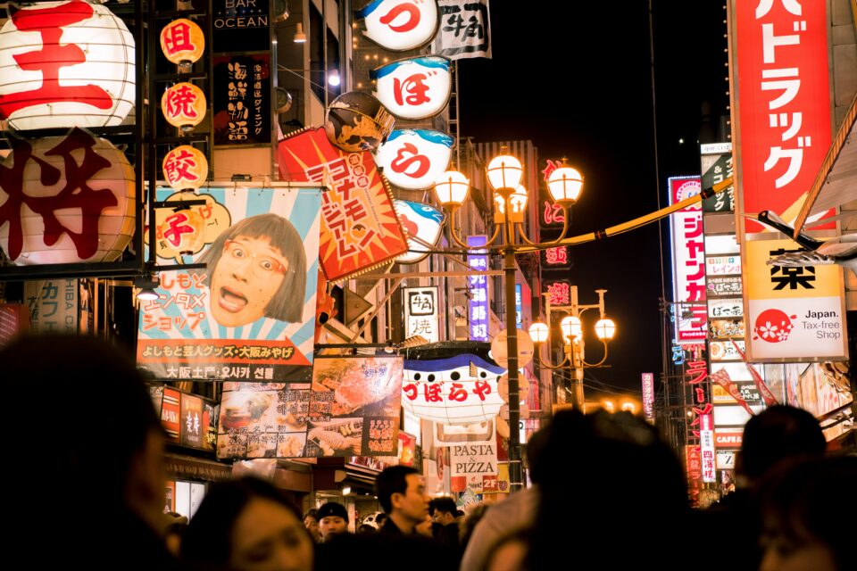 Eine Straße in Japan mit vielen leuchtenten Schildern.