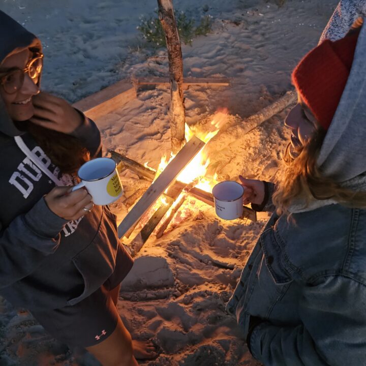 Leni und Lena trinken Gin am Lagerfeuer.