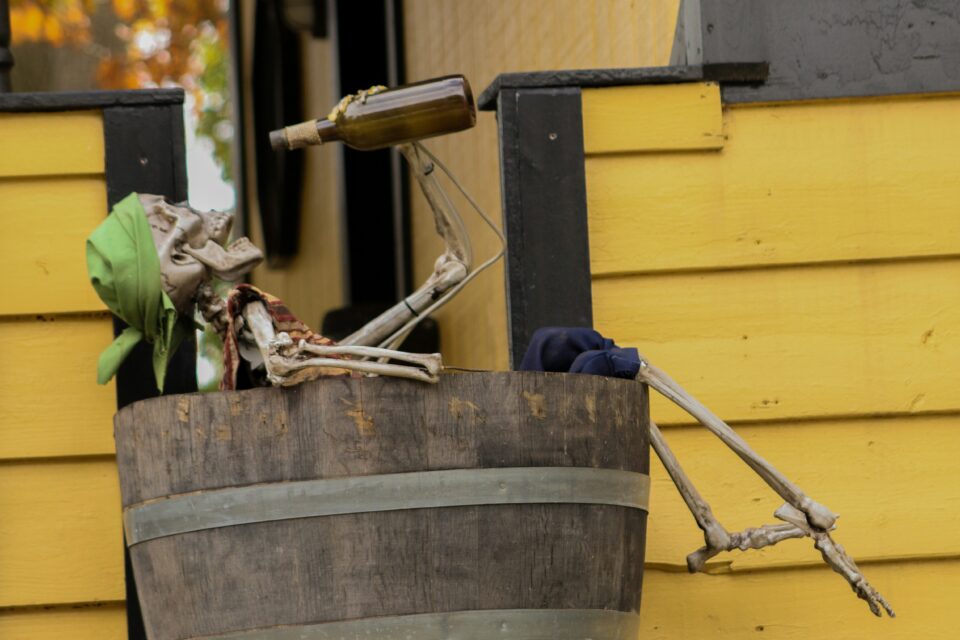 Skelett mit Piratentuch und Flasche in der Hand