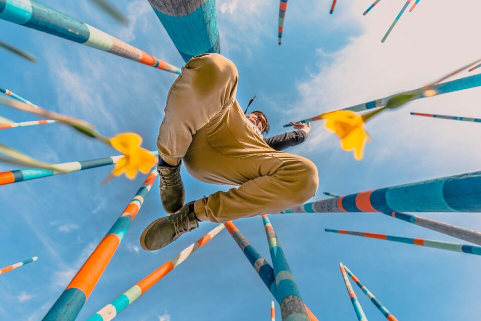 Mann springt in die Luft beim Tanzen, Foto von unten