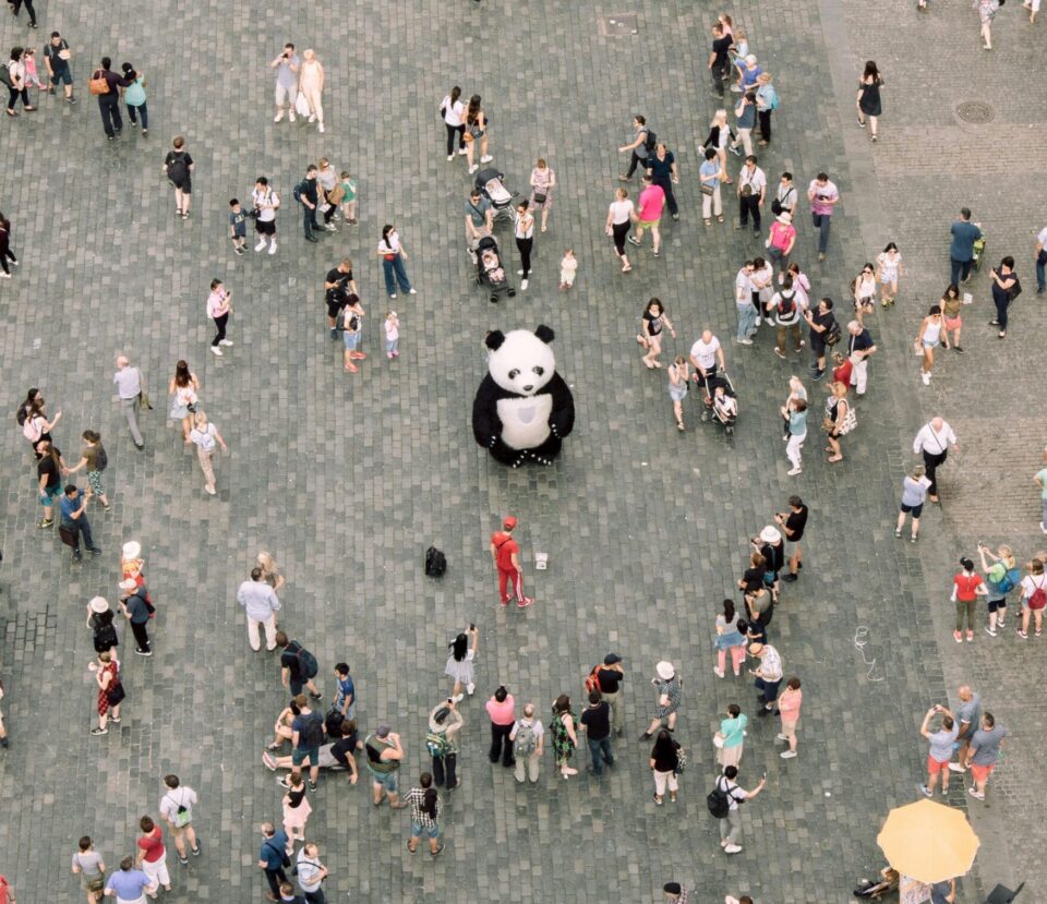 Pandafigur und Menschen auf einem Platz aus Vogelperspektive