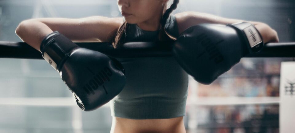 Frau mit Boxhandschuhen am Rand von Boxring