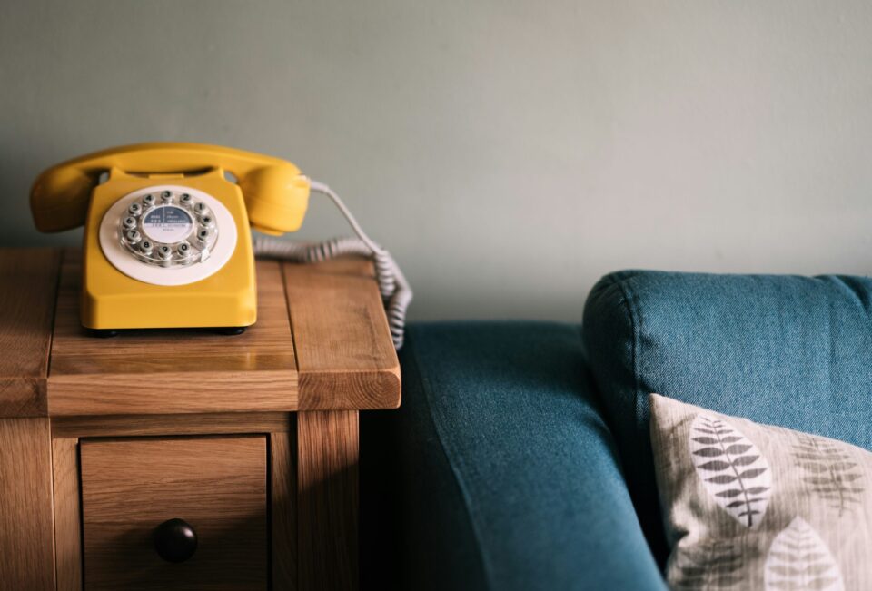 gelbes Telefon neben blauem Sofa